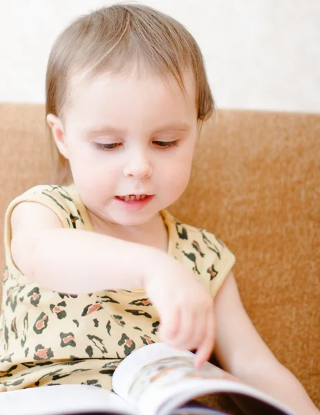 Vacker söt baby läser en bok — Stockfoto