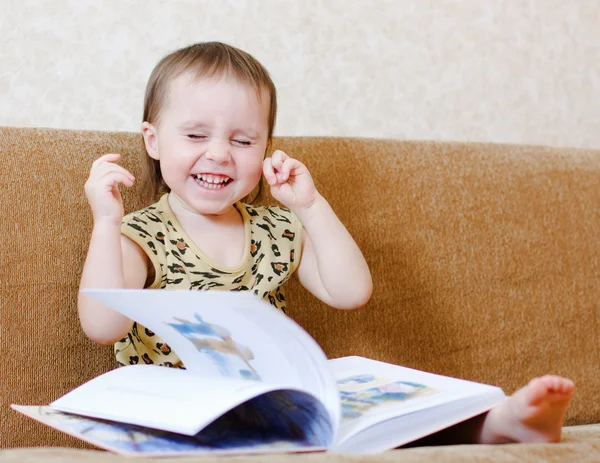 Vacker söt baby läser en bok — Stockfoto