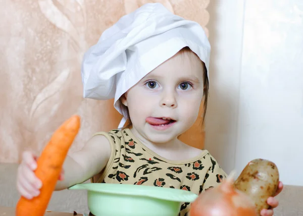 Beautiful cute little cook with vegetables — Stock Photo, Image
