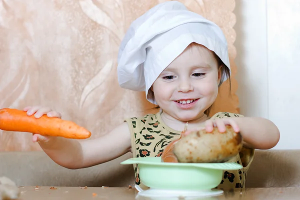 Beautiful cute little cook with vegetables — Stock Photo, Image