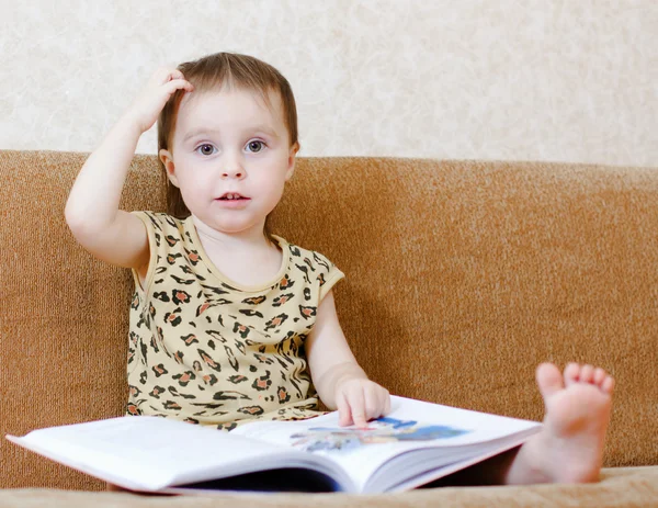 Vacker söt baby läser en bok — Stockfoto