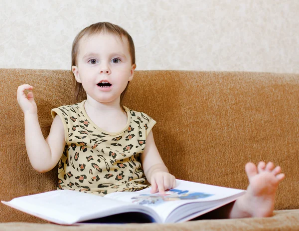 Vacker söt baby läser en bok — Stockfoto