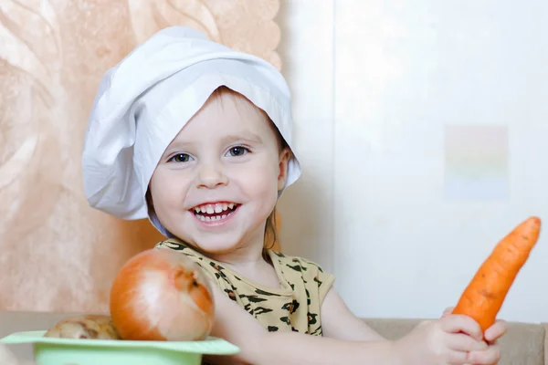 Beautiful cute little cook with vegetables — Stock Photo, Image