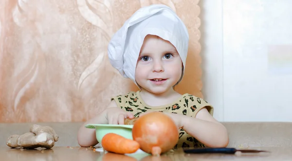 Beautiful cute little cook with vegetables — Stock Photo, Image