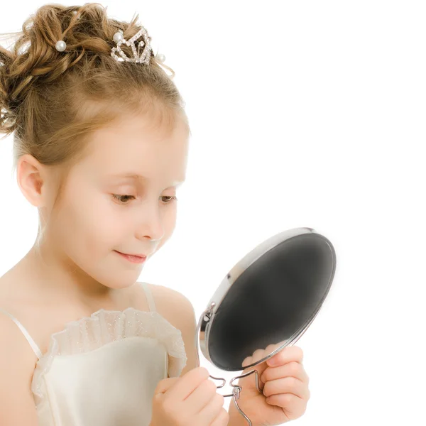 Pretty beautiful girl looks in the mirror. Royalty Free Stock Images