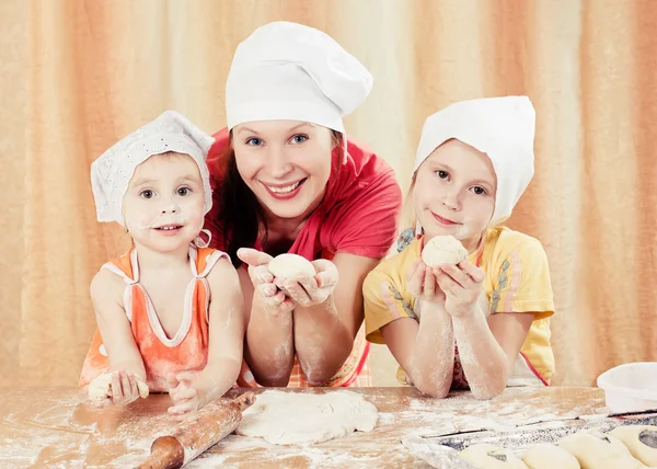 Mother with two daughters baking bread. — Stock Photo, Image