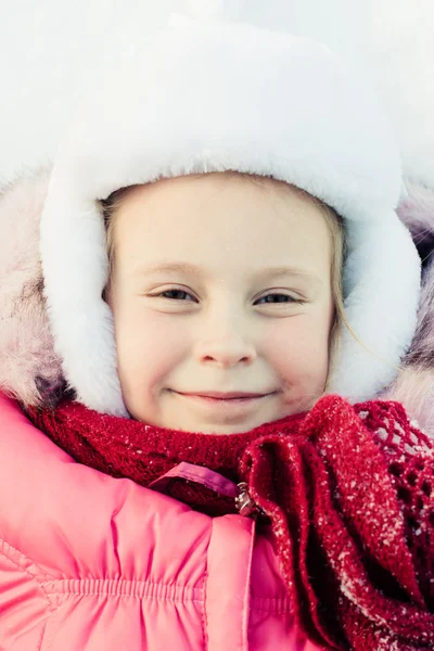 Счастливая девочка, лежащая на снегу — стоковое фото
