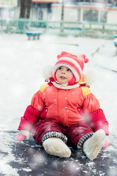 Zaskoczony dziecko siedzi na lodzie zimą. — Zdjęcie stockowe