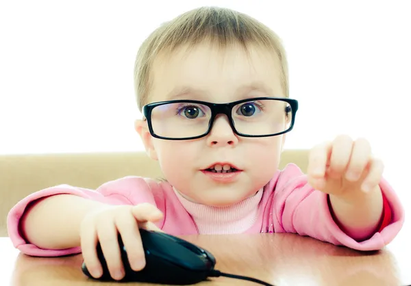Мила дитина в окулярах дивиться в ноутбук — стокове фото