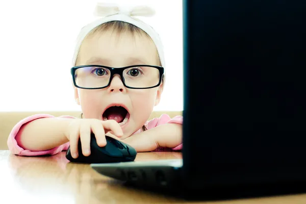 Cute baby with glasses looking into the laptop — Stock Photo, Image