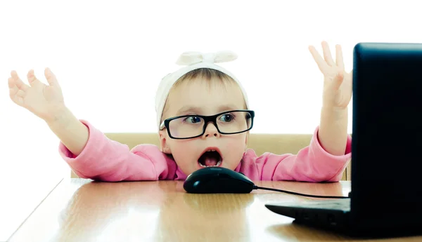 Cute baby with glasses looking into the laptop — Stock Photo, Image