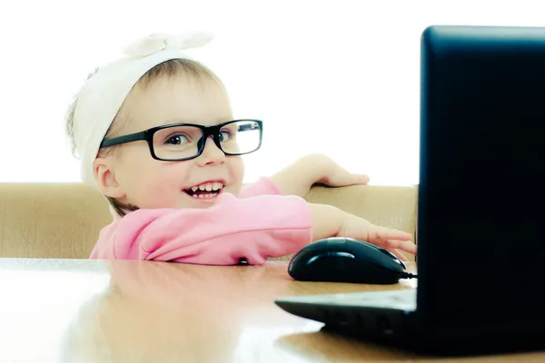 Niedliches Baby mit Brille schaut in den Laptop — Stockfoto