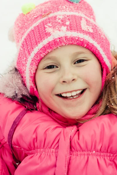 Hermosa chica feliz tumbada en la nieve — Foto de Stock