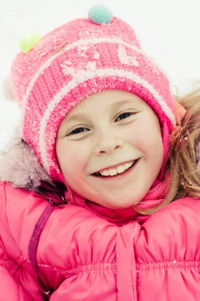 雪の上に横たわる美しい幸せな女の子 — ストック写真