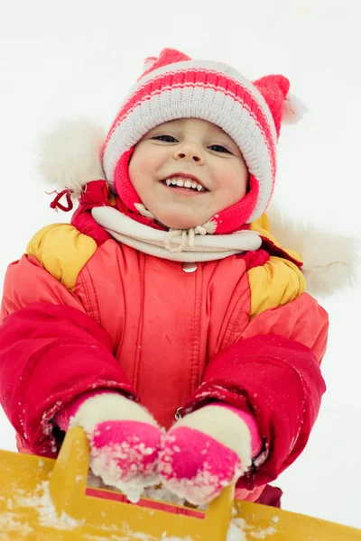 Hermosa chica feliz tumbada en la nieve — Foto de Stock