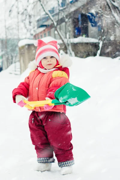 Il bambino scava la pala della neve — Foto Stock