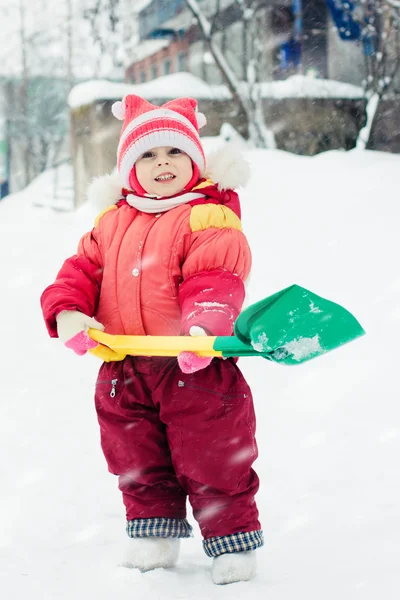 子供は雪のシャベルを掘り — ストック写真