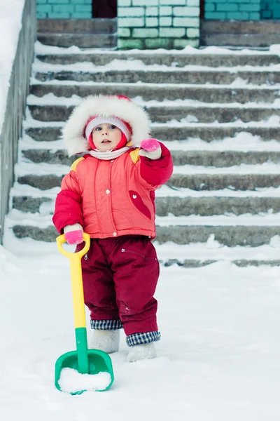 子供は雪のシャベルを掘り — ストック写真