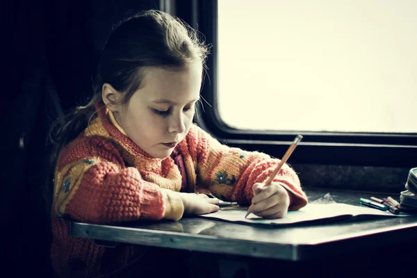 La fille assise à un bureau — Photo