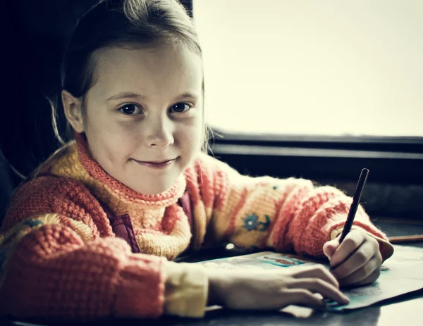 La fille assise à un bureau — Photo