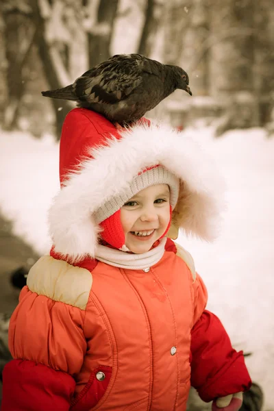 Dítě sedí na jeho hlavu holubice. — Stock fotografie