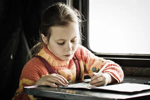 The girl sitting at a desk — Stock Photo, Image