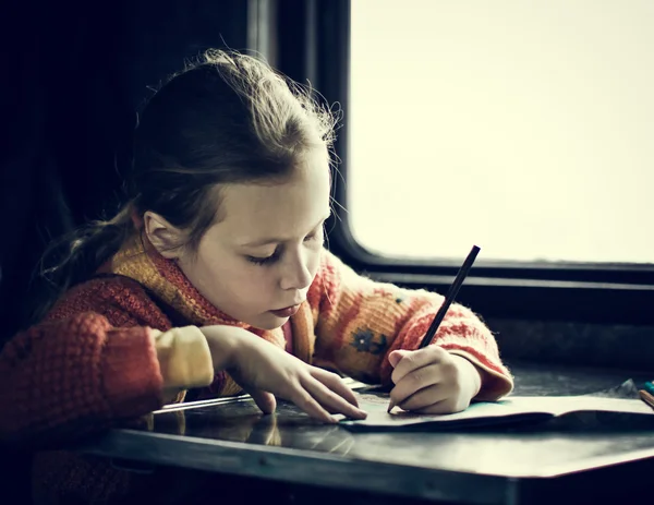 Het meisje zitten aan een bureau — Stockfoto