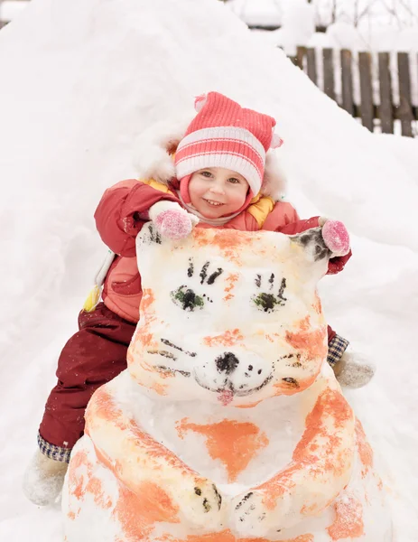 坐在一个雪人的快乐宝贝 — 图库照片