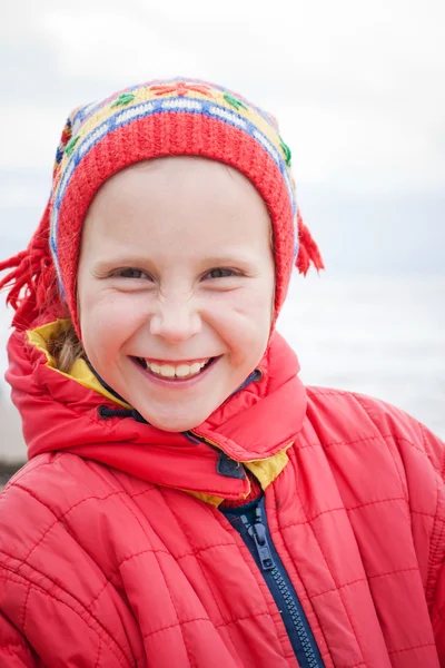 Het jonge meisje in een rode jas — Stockfoto