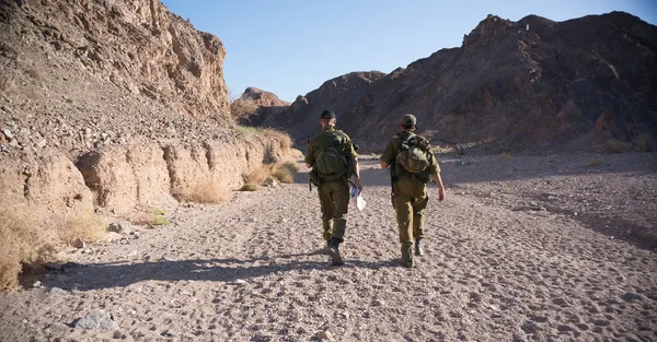 Soldiers patrol in desert — Stock Photo, Image