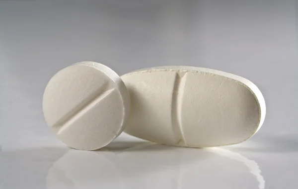Две таблетки белого лекарства Лицензионные Стоковые Изображения