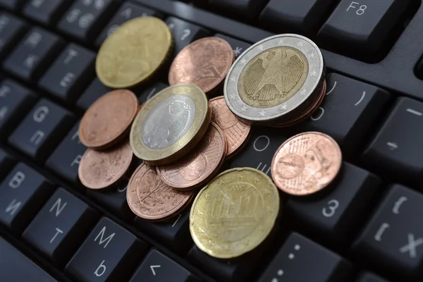 Monedas en el teclado — Foto de Stock