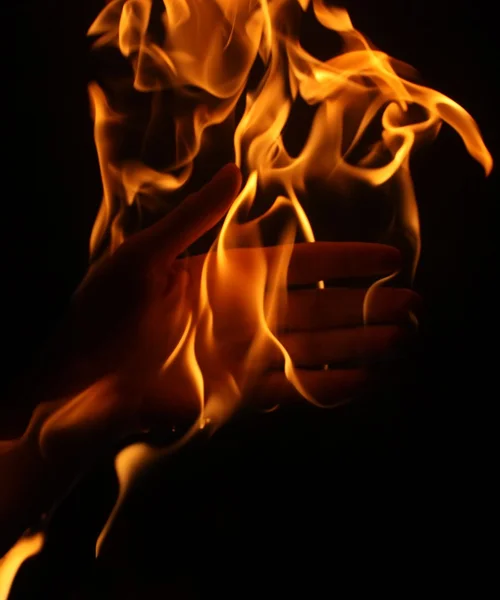Burning hand on black background — Stock Photo, Image