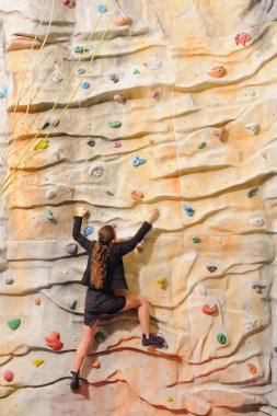 business woman on rock wall clipart