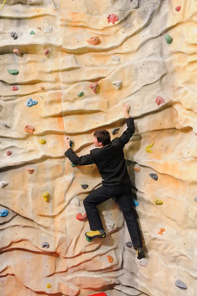 Man on rock wall in sport center — Stock Photo, Image