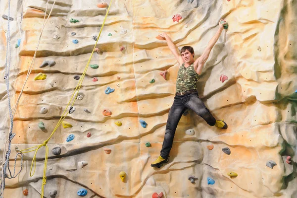 Man on rock wall in sport center — Stock Photo, Image