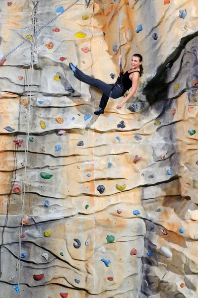 Woman on rock wall in sport center — Stock Photo, Image