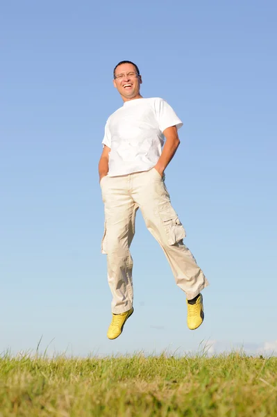 Man jumping on green field — Stock Photo, Image