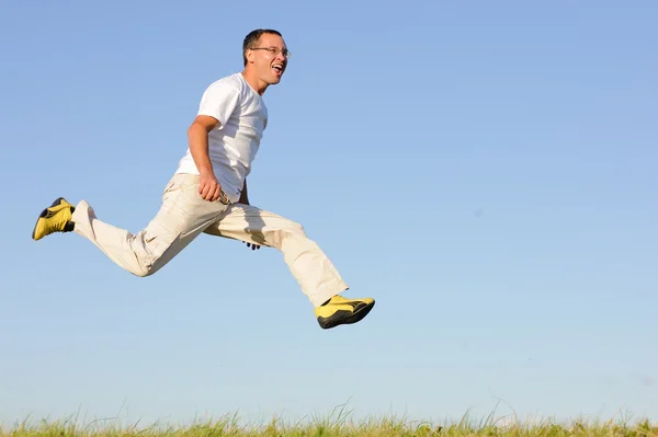 Man jumping on green field — Stock Photo, Image