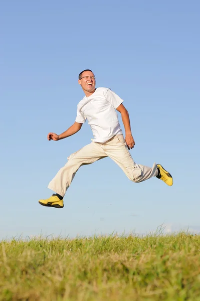 Man jumping on green field — Stock Photo, Image