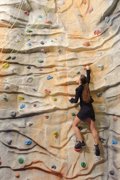 Business woman on rock wall — Stock Photo, Image