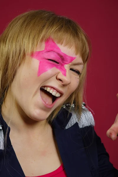 Nastolatka z różowym star na twarzy — Zdjęcie stockowe