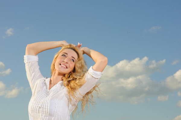 Portrait of beauty woman in white dress against the blue sky