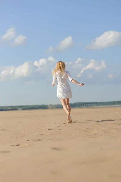 Beauty woman in white dress walking in desert — Stock Photo, Image