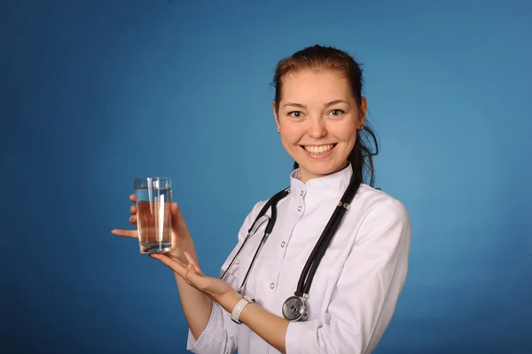 Giovane medico femminile amichevole con un bicchiere d'acqua — Foto Stock