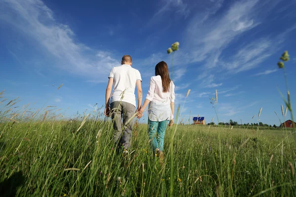 Paar läuft durch Feld — Stockfoto