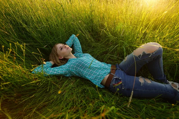 Молодая женщина лежит в высокой траве — стоковое фото