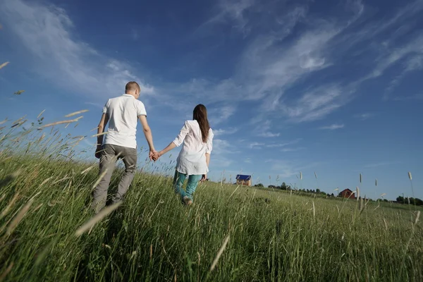 Paar läuft durch Feld — Stockfoto