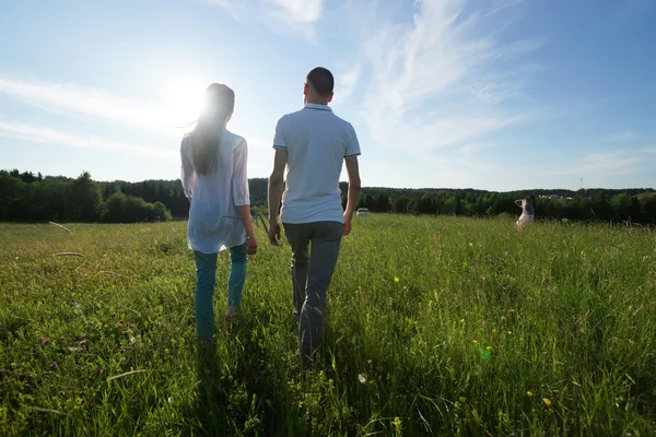Paar läuft durch Feld — Stockfoto