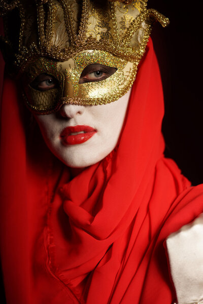 Closeup portrait of sexy woman in golden theater mask for desire concept